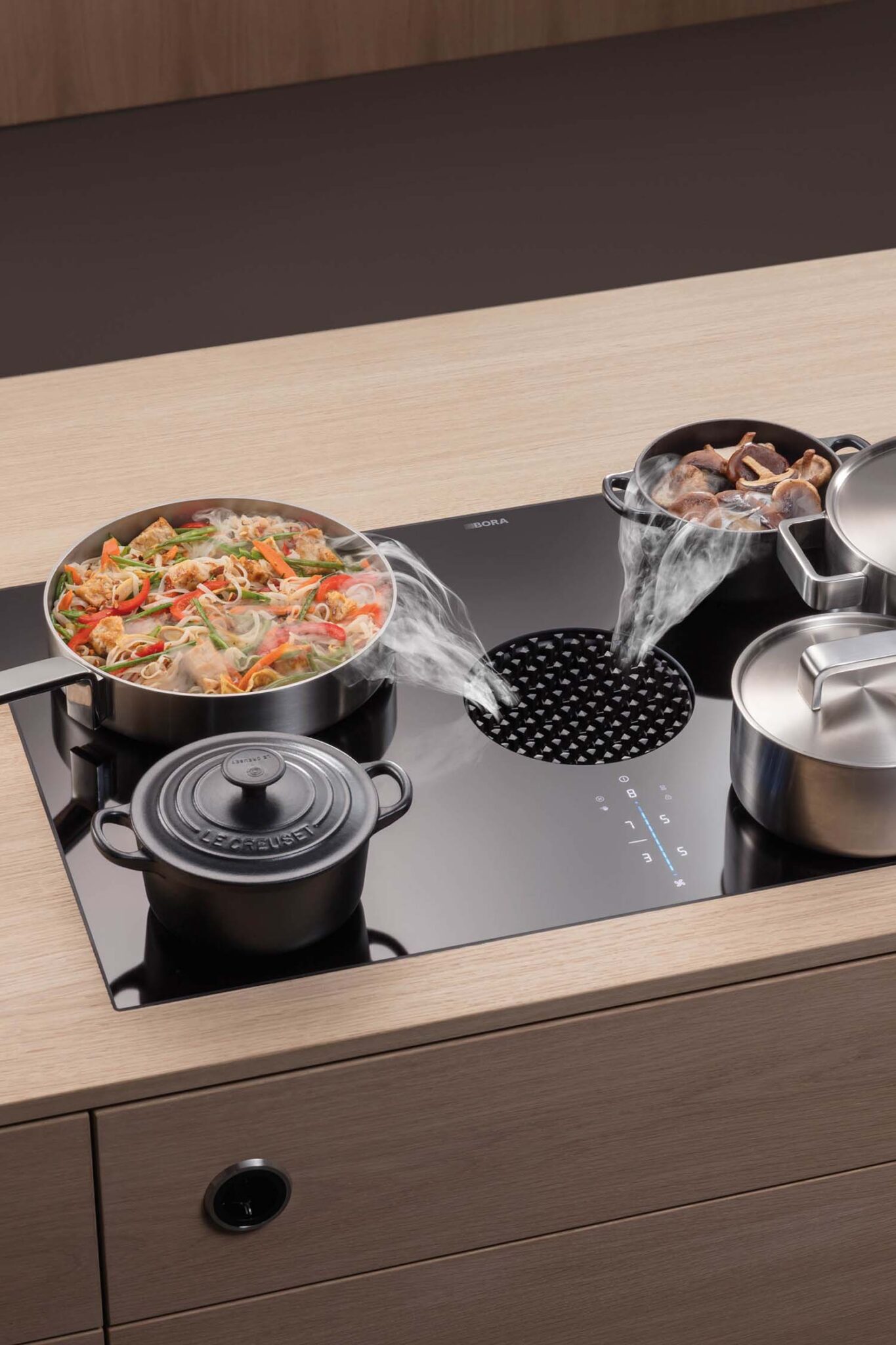 Top-down view of BORA X Pure 83 cm induction cooktop with integrated downdraft extractor and cookware in use.